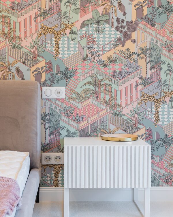 Bedroom with a colourful illustrated cityscape wallpaper in soft pinks and teals