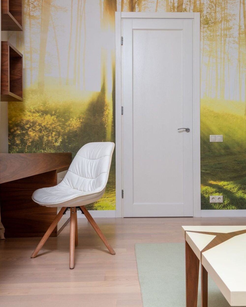 Study with a soft forest-scene mural wallpaper in muted green and grey tones